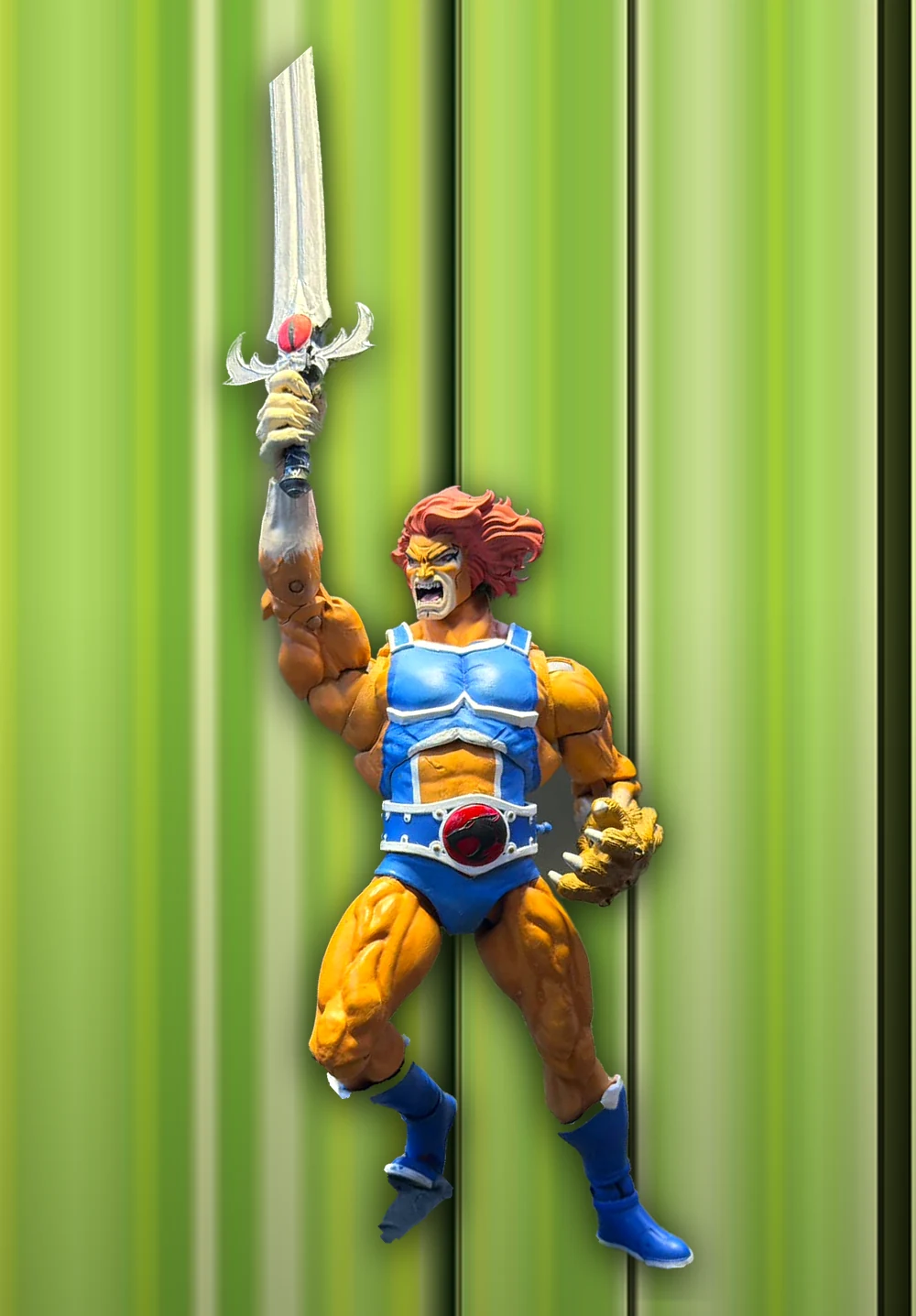 The custom Lion-O photographed roaring with the Sword of Omens raised and the claw shield out to the side, cut out and centred against the same vertical green striped background as the 2002 cover