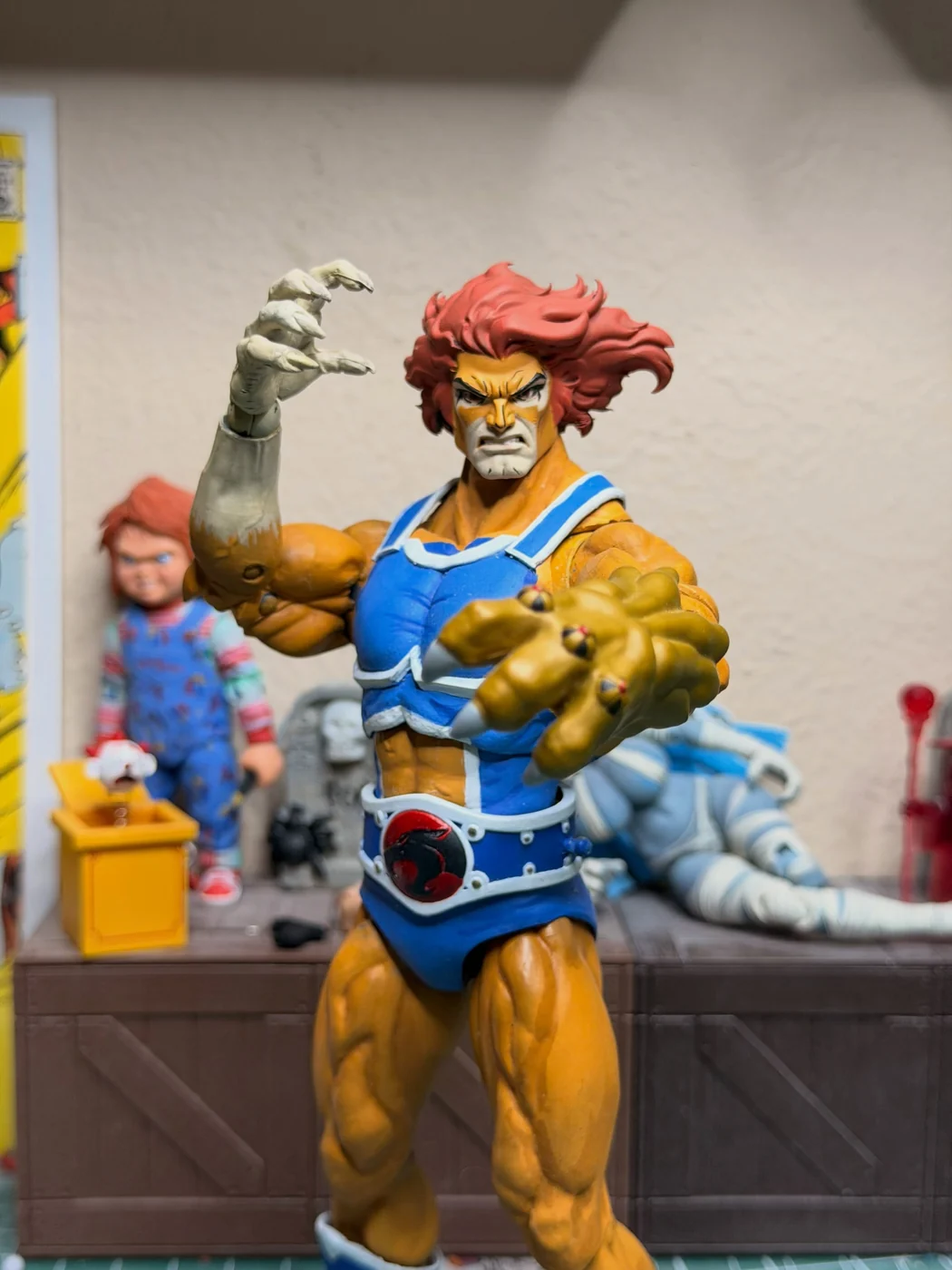 Close view of the finished Lion-O reaching toward the camera with the claw shield, face set in a snarl, red mane blown back