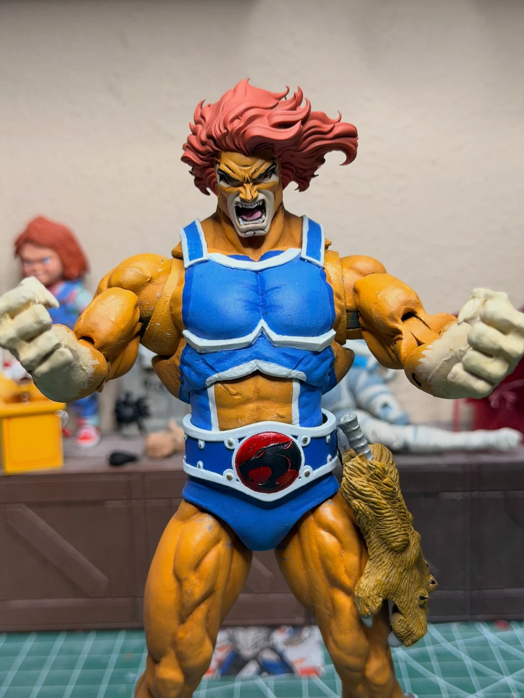 Close view of the finished Lion-O roaring with both fists raised, the claw shield hanging at the hip, the ThunderCats insignia belt front and centre