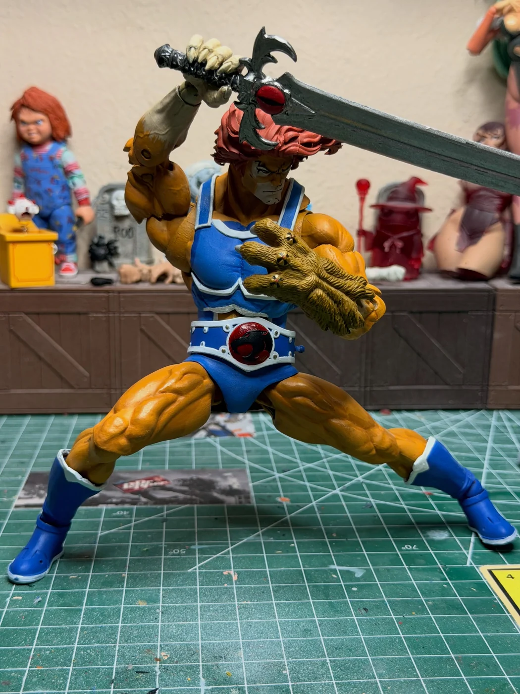 The custom Lion-O in a wide braced stance swinging the Sword of Omens across the body, claw shield raised