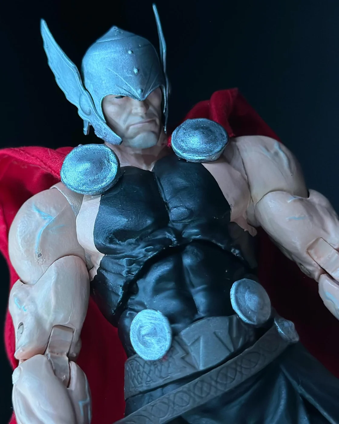 Close view of a custom Esad Ribic style Thor figure, winged silver helmet, black tunic with silver discs, lightning veining painted onto the arms, red cape behind