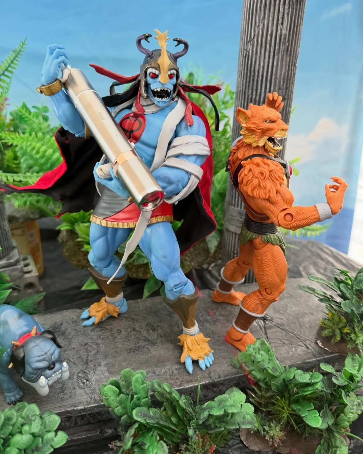 Close view of the Mumm-Ra figure holding a large custom built laser pointer prop, with Jackalman standing beside him laughing