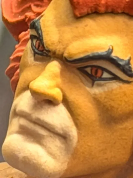 Macro of the painted eye and brow markings on the Mezco One:12 Lion-O